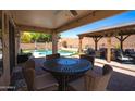 Inviting outdoor patio with comfortable seating, a dining table, and a view of the backyard pool at 9052 E Hobart St, Mesa, AZ 85207