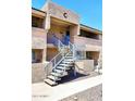 Inviting two-story condo with exterior staircase and neutral-toned stucco under a clear blue sky at 10828 N Biltmore Dr # 230, Phoenix, AZ 85029