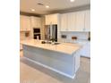 Bright, open kitchen features a large center island and white cabinets for a clean, modern look at 11074 W Tonto St, Avondale, AZ 85323