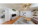 Bright living room with hardwood floors, ceiling fan, and decorative plants above a half wall, creating a cozy atmosphere at 11596 W Sierra Dawn Blvd # 33, Surprise, AZ 85378