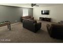 Spacious living area features carpeted floors, a TV, sofas, and a foosball table at 11644 W Redfield Rd, El Mirage, AZ 85335