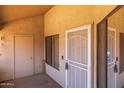 Enclosed patio with a security screen door and neutral colored stucco walls at 11666 N 28Th Dr # 295, Phoenix, AZ 85029