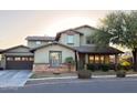 Charming two-story home with a well-maintained lawn and a welcoming front porch at 13686 N 151St Dr, Surprise, AZ 85379