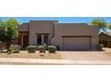 Contemporary home featuring a neutral color palette, a well-maintained front yard, and a two-car garage at 14045 E Geronimo Rd, Scottsdale, AZ 85259