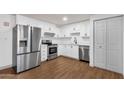 Modern kitchen with stainless steel appliances, white cabinets, and wood-look flooring at 14215 N 36Th Way, Phoenix, AZ 85032