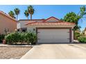 Charming home featuring a red tile roof, two-car garage, and drought-resistant landscaping at 1425 E Commerce Ave, Gilbert, AZ 85234