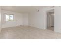 Bright living room with neutral tile flooring, a large window, and a classic white door at 2220 W Dora St # 220, Mesa, AZ 85201