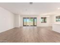 Spacious living room with hardwood floors, bright windows, and access to the backyard at 25221 N 131St Dr, Peoria, AZ 85383