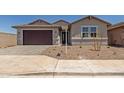 Charming single-story home boasts neutral stucco, desert landscaping, and a dark brown garage door at 25319 N 131St Dr, Peoria, AZ 85383