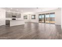 Open-concept living area featuring stylish wood-look tile flooring and natural light at 25324 N 131St Dr, Peoria, AZ 85383