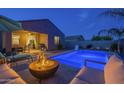 Tranquil backyard featuring a sparkling pool, fire pit, and comfortable lounge seating at 3661 E Appaloosa Dr, San Tan Valley, AZ 85140
