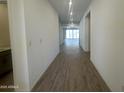 Bright hallway with wood-look tile flooring that leads to an open living space with natural light at 47219 W Pecan Woods --, Maricopa, AZ 85139