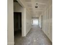 Interior view of a long hallway with fresh drywall, showcasing the home's layout and natural light at 47219 W Pecan Woods --, Maricopa, AZ 85139