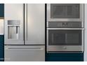 Close-up of stainless steel GE Profile appliances, including a refrigerator, microwave, and oven, in a modern kitchen at 491 E Aurora Dr, San Tan Valley, AZ 85140