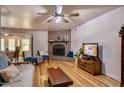 Inviting living room with a brick fireplace, ceiling fan, and wood-look flooring at 7001 E Flossmoor Ave, Mesa, AZ 85208