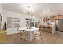 Bright dining area with a white round table, modern light fixture, and open flow to the kitchen at 7647 E Montecito Ave, Scottsdale, AZ 85251