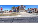 Inviting two-story home showcasing desert landscaping, a 2-car garage, and a vibrant red bush at 7844 W Jenan Dr, Peoria, AZ 85345