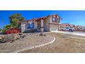 This home features red brick accents, a two-car garage, and desert landscaping at 7844 W Jenan Dr, Peoria, AZ 85345