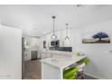 Modern kitchen boasts white cabinetry, marble countertops, a stylish island, and stainless steel appliances at 855 S Revolta Cir, Mesa, AZ 85208