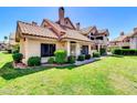 Beautiful exterior view showcasing a charming house with a tile roof, green lawn, and neatly trimmed bushes at 1001 N Pasadena Dr # 105, Mesa, AZ 85201