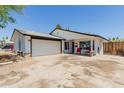 Charming single-story home with a well-manicured lawn, covered front porch, and attached two car garage at 1017 S San Jose Cir, Mesa, AZ 85202