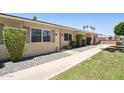 Exterior view showcasing walkway, lush landscaping, and easy access at 10921 W Santa Fe Dr, Sun City, AZ 85351