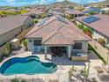Aerial view showcases a private backyard oasis with a pool, outdoor seating, and solar panels on the roof at 12027 S 183Rd Dr, Goodyear, AZ 85338