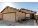 Home exterior features a two car garage, drought resistant front yard landscaping and covered entry at 12034 W Aster Dr, El Mirage, AZ 85335