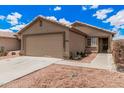 Single-story home with a two-car garage, desert landscaping and a neutral color scheme at 12034 W Aster Dr, El Mirage, AZ 85335