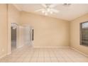 Spacious living room featuring tile flooring, a ceiling fan, and lots of natural light at 12034 W Aster Dr, El Mirage, AZ 85335