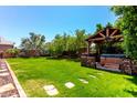 Spacious backyard featuring lush lawn, desert landscaping and covered hot tub at 13213 W Jacobson Dr, Litchfield Park, AZ 85340