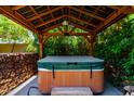 Covered hot tub featuring wood beam construction and stone accents at 13213 W Jacobson Dr, Litchfield Park, AZ 85340