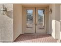 Close-up of elegant double front doors with decorative glass and a brick walkway leading up to the entrance at 13304 W Palo Verde Dr, Litchfield Park, AZ 85340