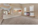 Bright living room featuring a cozy fireplace and ample natural light from surrounding windows at 13304 W Palo Verde Dr, Litchfield Park, AZ 85340