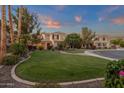 Lush front yard with a curved walkway, mature trees, and well-manicured landscaping create a welcoming entrance at 1356 E Flamingo Ct, Gilbert, AZ 85297