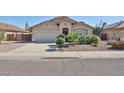 Inviting single-story home with a well-maintained front yard and an attached two-car garage at 15731 W Redfield Rd, Surprise, AZ 85379