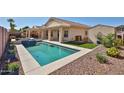 Beautiful backyard featuring a private pool, covered patio, and low-maintenance desert landscaping at 15731 W Redfield Rd, Surprise, AZ 85379
