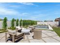 Inviting backyard oasis featuring a sleek pool, stylish patio furniture, and lush landscaping, perfect for relaxation and entertaining at 17084 N Palo Pino St, Maricopa, AZ 85138