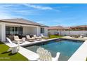 Backyard oasis featuring a modern pool, lounge chairs, and lush artificial turf at 17084 N Palo Pino St, Maricopa, AZ 85138