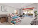 Cozy living room with bright, neutral walls, access to patio, modern ceiling fan, and comfortable furnishings at 1803 E Palm Beach Dr, Chandler, AZ 85249