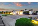Beautiful single-story home featuring stone accents, lush lawn, manicured landscaping, and a two-car garage at 20165 E Via Del Palo Dr, Queen Creek, AZ 85142