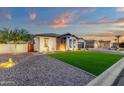 Well-maintained single-story home featuring stone accents, lush lawn, manicured landscaping, and a two-car garage at 20165 E Via Del Palo Dr, Queen Creek, AZ 85142