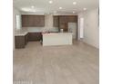 Open-concept kitchen with brown cabinets, white countertops, an island, and tile flooring throughout the room at 2469 W Rowel Rd, Phoenix, AZ 85085