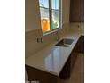 Kitchen sink with white countertop, a silver faucet, and a large window, offering a view of the neighborhood at 2469 W Rowel Rd, Phoenix, AZ 85085