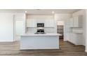 Modern kitchen featuring a large island, white cabinetry, and stainless steel appliances at 25283 N 183Rd Dr, Wittmann, AZ 85361