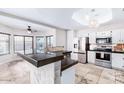 Bright kitchen featuring stainless steel appliances, granite countertops, and a breakfast bar with views of the backyard at 3761 W Kent Dr, Chandler, AZ 85226