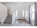 Bright foyer with staircase, neutral tile flooring and ample natural light from the sidelight windows at 44175 W Knauss Dr, Maricopa, AZ 85138