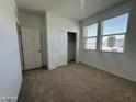 Well-lit bedroom with sliding closet doors, carpet flooring and large windows at 47230 W Cansados Rd, Maricopa, AZ 85139