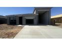 Contemporary gray single-story home features two garages and a concrete driveway at 47230 W Cansados Rd, Maricopa, AZ 85139