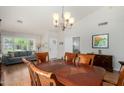 Open-concept dining area with wooden table and view of the bright living room at 6018 W Villa Maria Dr, Glendale, AZ 85308